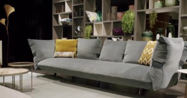 Modern contemporary Minimalist living room with gray furniture. Luxury Modern House Interior With Corner Sofa, Chairs and Bookshelf. Fashionable furniture. Real Estate private home.