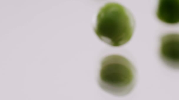 Many Ripe Green Peas Rolling Reflective Surface Isolated White Background — Vídeo de Stock