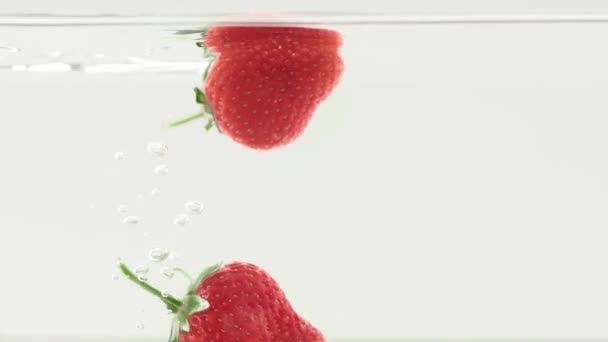 딸기는 배경에 속으로 떨어졌다 딸기를 떨어뜨리는 속에서 딸기가 식품에 맛있는 — 비디오