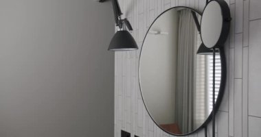 Modern Interior with round mirror, minimalist interior in white colors with bathroom accessories , mirror and lamp in modern interior. Modern White Bathroom. Elegance Design Interior.