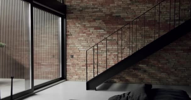 用褐色的旧砖墙装饰着黑色楼梯和大的滑动窗户的现代公寓 用砖墙装饰着简约的客厅 室内质感 砖墙背景 — 图库视频影像