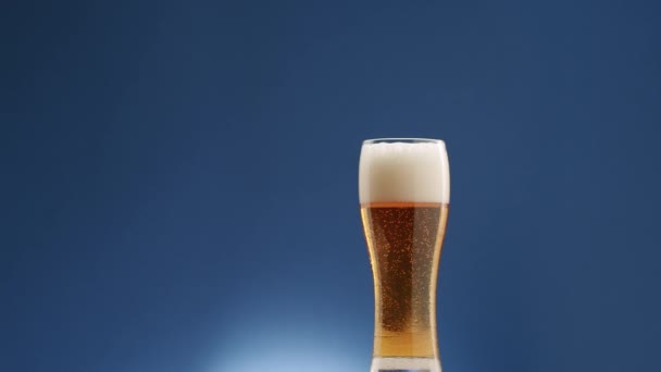 Ein Glas Bier Gefilmt Studio Auf Blauem Hintergrund Tropfen Auf — Stockvideo