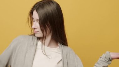 Neşeli Kadın Portresi ellerini oynatmak için ritmik bir şekilde müzik eşliğinde gülümsüyor. Sarı Arkaplanda Zıpla Yavaş Hareket. Dans ediyor, eğleniyor, jestler yapıyor..