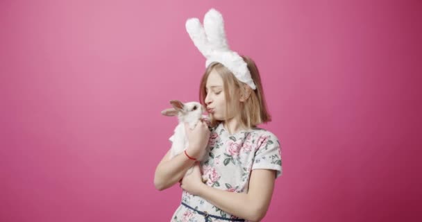 Paskalya Kutlaması Sırasında Pembe Arka Plan Karşısında Tavşan Kulaklı Gülümseyen — Stok video