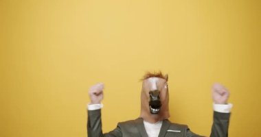 Man with horse mask making funny gestures. Business man with horse Mask. Fun and happiness concept. Funny Guy in Gray Suits Dance with Horse Mask, April 1, Fools Day. Masquarade idea.