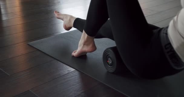 Tracking Shot Female Stretching Legs Foam Roller While Exercising Mat — Vídeo de Stock