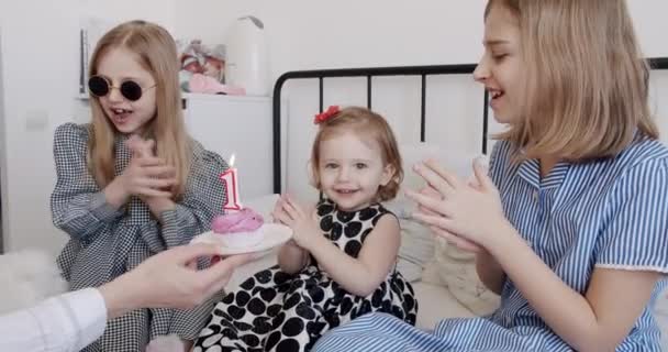 언니들에게 둘러싸인 살난귀여운 소녀의 케이크 위에서 촛불을 친구들 그리고 행사를 — 비디오