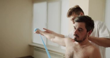 Fizyoterapi Programı A Man, elastik bant ile doktor 