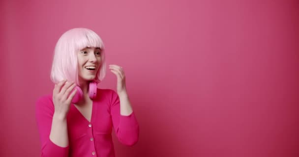 Şaşırmış Genç Bir Kadın Başka Tarafa Bakıyor Kablosuz Kulaklıklı Boyalı — Stok video