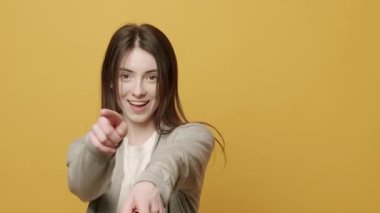 Neşeli Kadın Portresi ellerini oynatmak için ritmik bir şekilde müzik eşliğinde gülümsüyor. Sarı Arkaplanda Zıpla Yavaş Hareket. Dans ediyor, eğleniyor, jestler yapıyor..