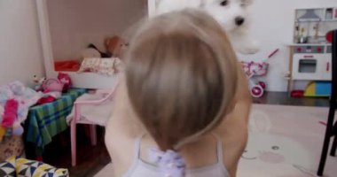 7 yaşındaki kız evde köpeğiyle oynuyor, çok mutlu ve heyecanlı, köpekle sağlıklı aktiviteler yapıyor. Oyuncak dolu çocuk odası ve küçük çocuklar için meslekler.