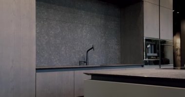 Modern ve geniş ahşap mutfak odası. Gayrimenkul. Bir adası olan lüks bir mutfak. Lüks evde modern iç mekan. Modern Krom Musluk. Yeni Ev 'de minimalist tasarım. Yeni Klasik Biçim