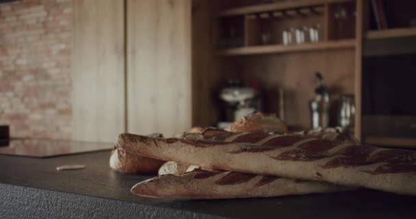テーブルの上に多くのパンとモダンで広々とした木製のキッチンルーム 不動産だ 新家のミニマリストデザイン 本物の高級デザインインテリア ネオクラシックスタイル 居心地の良いインテリア — ストック動画