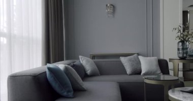 Modern contemporary Minimalist living room with gray furniture. Luxury Modern House Interior With Corner Sofa and round table. Fashionable furniture. Cozy Modern Furniture Design. Luxury Elegant Room