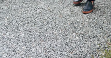 Siyah ayakkabılı ve takım elbiseli bir iş adamının bacakları dekoratif taşın üzerinde yürüyor. Ayakkabılar, yürüyüş ve bir iş adamıyla şehir. Modern ayakkabı kavramı, seyahat.
