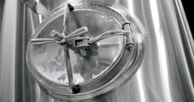 Stainless steel tanks for brewing beer. Huge stainless vats in a brewery. Equipment for beer fermentation. Brewing equipment. Factory, brewery concept. Modern brewery.