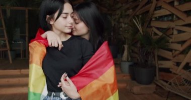 Couple, Lgbt and lesbian women at home. Embrace, smile and holding each other with flag. Pride Event, friendship concept. Romance and portrait of lesbian couple enjoying. LGBT rights, Lesbian family.