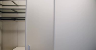 Şeffaf sürgülü kapı giysi dolabıyla soyunma odasına açılıyor. Kıyafetli ev kıyafetleri. Modern Minimalist Sürgülü Kapı. Modern Soyunma Odası.