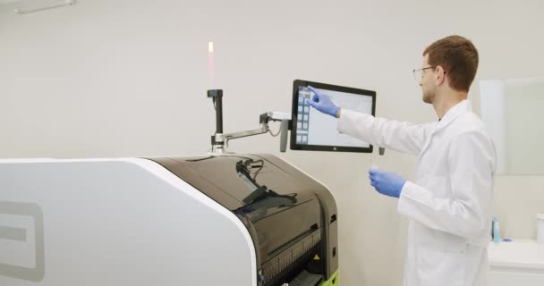 チューブ付き血液検査機 コンピューター機器を使った血液検査 血液検査機は実験室でサンプルをチェックします 作業プロセス中の自動化されたマシン 血液や尿のサンプル分析 — ストック動画