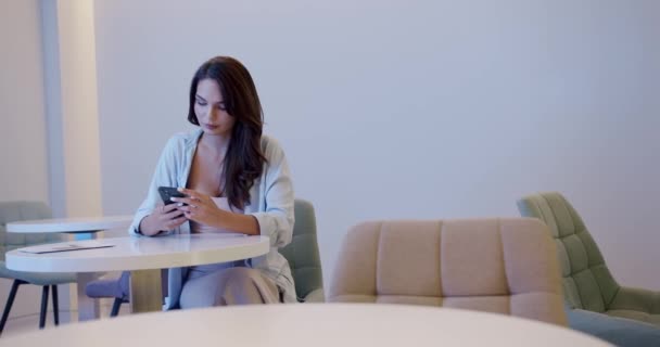 Genç Esmerin Boyna Dokunuşunu Bekleme Odasındaki Masada Otururken Sosyal Medyayı — Stok video