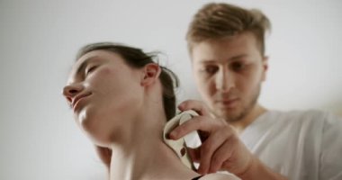 IASTM, Rhomboid ve Acı için miyofasiyal tahliye, akıllı aletler kullanan terapist, kürek ağrısını tedavi etmek için IASTM aletini kullanıyor, fasya manipülasyonları uyguluyor boynuna yumuşak doku tedavisi uyguluyor. 
