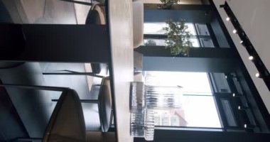 Modern Yemek Odası İçi. Yemek odasında zarif ve rahat bir ev var. Minimalist ahşap yemek masası ve sandalyeler. Modern stil masa. Mutfak odasının içi. Dikey video.