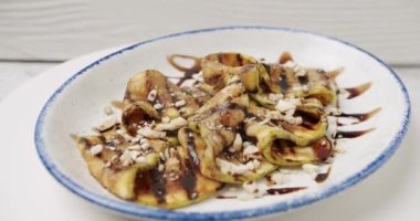 Kızarmış patlıcan. Dönen beyaz tabakta fındıklı lezzetli sebzeler. Izgara restoran yemeği. Kızarmış patlıcan. Patlıcan kızartmasının yakın çekimi..