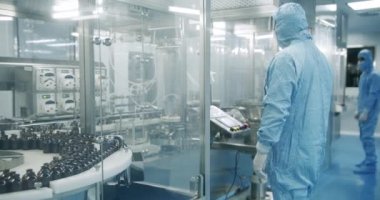 Fabrika Temizlik Odası. İlaç, Biyoteknoloji ve Yarı iletken Üretim Süreci. Steril Koruyucu Giysilerdeki Bilim adamları Modern Laboratuvar Üzerinde Çalışıyor.