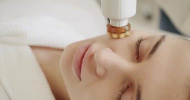 Güzellik uzmanı ultrason yüz masajı yapıyor. Kozmetik uzmanı yüz masajı yapar. Yüz yenileme prosedürü. Yüz süpürgesi masaj terapisi. Yüz güzelliği tedavisi.