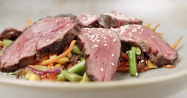 Yakın Dilimlenmiş Et. Az pişmiş biftekli ızgara sebze salatası. Dilimlenmiş sığır eti ve pişmiş sebzeli taze yaz salatası. Biftek ızgara Makro. Dana eti dilimi.