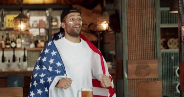 優勝後の応援とエキスパートの皆さん おめでとうございます アメリカの国旗を持つ男 ビールを飲んでスポーツゲームを見て — ストック動画