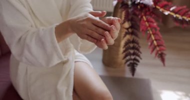 Genç ve güzel bir kadın eline losyon sürüyor ve cilt kremi sürüyor. Masaj ve serum. Hyaluronik asit, el kremi, cilt rutini, elinde pipetle nemlendirici bırakan kadın..