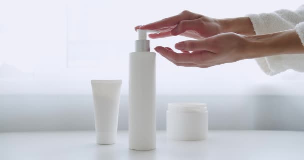 白い部屋の背景にきれいな手でクリームボトルに指を押しボタン スキンケア 衛生健康的なライフコンセプト 手に保湿クリームを適用ポンププラスチック化粧水ボトルを押す女性の手 — ストック動画