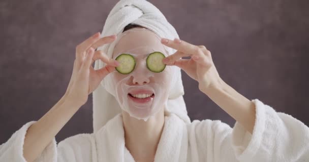 Giovane Bella Donna Accappatoio Asciugamano Testa Applicare Maschera Foglio Cosmetico — Video Stock