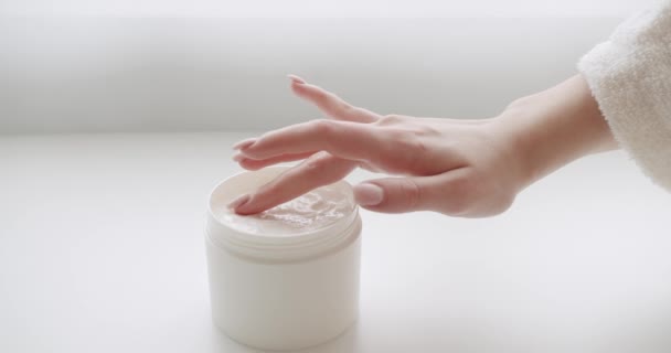 クローズアップの女性はクリームを取り 瓶から保湿化粧水を取り 女性の手は手に保湿クリームを適用した化粧水ボトルを取ります 化粧品やスキンケアマッサージ用スポンジ付きボトル — ストック動画