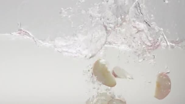 Fallande Äppelklyftor Rent Vatten Långsam Rörelse Statisk Skott Transparent Klart — Stockvideo