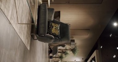 Gri mobilyaları ve tahta duvarları olan modern Minimalist oturma odası. Köşedeki kanepe ve sandalyeli lüks Modern Ev İçişleri. Moda mobilyalar. Minimalist İç İşleri. Dikey video.