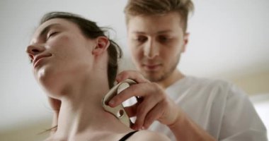 IASTM, Rhomboid ve Acı için miyofasiyal tahliye, akıllı aletler kullanan terapist, kürek ağrısını tedavi etmek için IASTM aletini kullanıyor, fasya manipülasyonları uyguluyor boynuna yumuşak doku tedavisi uyguluyor. 