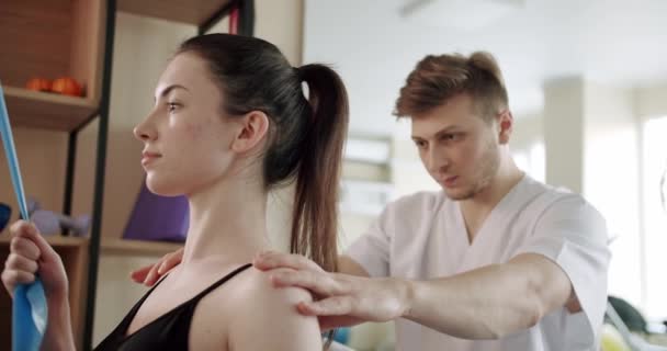 Άνδρας Θεραπευτής Αγγίζοντας Πίσω Και Βοηθώντας Γυναίκα Ασθενή Κάνει Άσκηση — Αρχείο Βίντεο