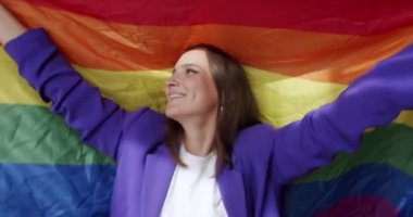 Lgbt kadınları evde gökkuşağı bayrağıyla dans ediyorlar. Sarıl ve tut. Mutlu bayan ve gülümse. cinsel çeşitlilik, LGBTQI, Gurur Etkinliği, LGBT Onur Ayı, lezbiyen mutlu bayan portresi. LGBT kavramı
