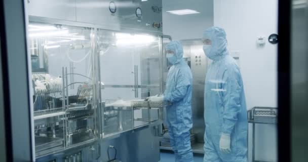 无菌制药实验室 科学家在那里的保护层 穿着消毒防护服的科学家们在一个现代实验室工作 工厂清洁室 — 图库视频影像