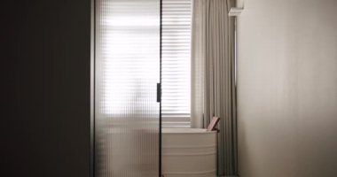 Luxury Bathroom Interior, minimalist interior in white colors with bathroom accessories , transparent door, round mirror in modern interior, bathtub modern design. Luxury cozy white Apartment.