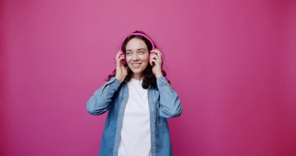 Statyczne Ujęcie Wesołej Młodej Kobiety Kapturze Bezprzewodowymi Słuchawkami Zaciskającymi Dłońmi — Wideo stockowe