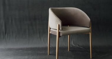 Rahat ve rahat bir sandalye. Modern, rahatlatıcı koltuğa oturmuş. Evdeki bej renkli koltuğun iç dekorasyonunun kamyon çekimi. Modern izole edilmiş gri arka planda bej minimalist sandalye