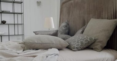 Zarif iç tasarım. Minimalist Kahverengi ve Gri Yatak Odası. Bir sürü yastıklı yatak. Minimalist İskandinav tarzı iç mekan. Mobilyalı modern lüks yatak odasının neoklasik iç mimarisi.