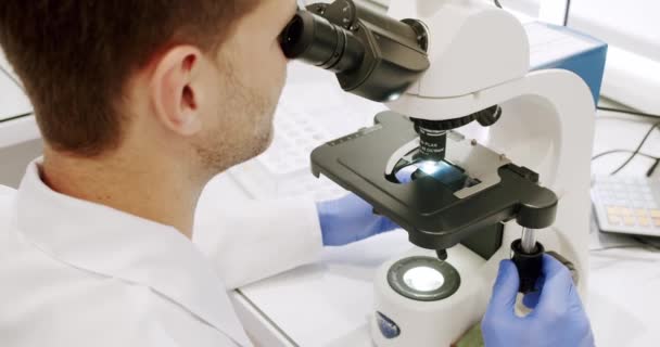 Laboratuvar Önlüklü Lateks Eldivenli Bir Adam Gündüz Klinikte Çalışırken Mikroskop — Stok video