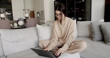Gözlüklü bir iş kadını uzak bir iş yerinde dizüstü bilgisayarla çalışıyor. Evde dizüstü bilgisayar kullanan bir kadın. Dizüstü bilgisayarda yazan genç bir iş kadını. İnternette çalışan güzel bir kadın.