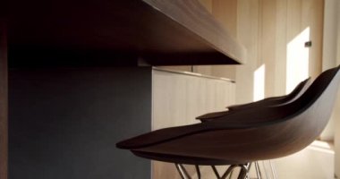 Açık Ahşap Duvar ve Zemin. Modern mutfak ve minimalist apartmandaki mutfak odasında kahverengi sandalyeler. Minimalist yemek masası olan modern mutfak odası. Minimalist mutfak, doğal ahşap yemek alanı.
