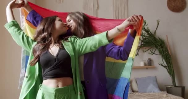 互いを抱擁し 誇り虹のフラグを保持します 友情の概念 レズビアンファミリー 愛を分かち合い 手をつなぐ支援をする2人の女性 生活様式と関係 Lgbtの概念 — ストック動画