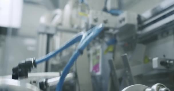 医療工場での製造ライン ロボットアームはコンベアベルトに薬液を詰めます 自動生産ラインでパッケージ化された商品 医薬品製造の生産ライン — ストック動画
